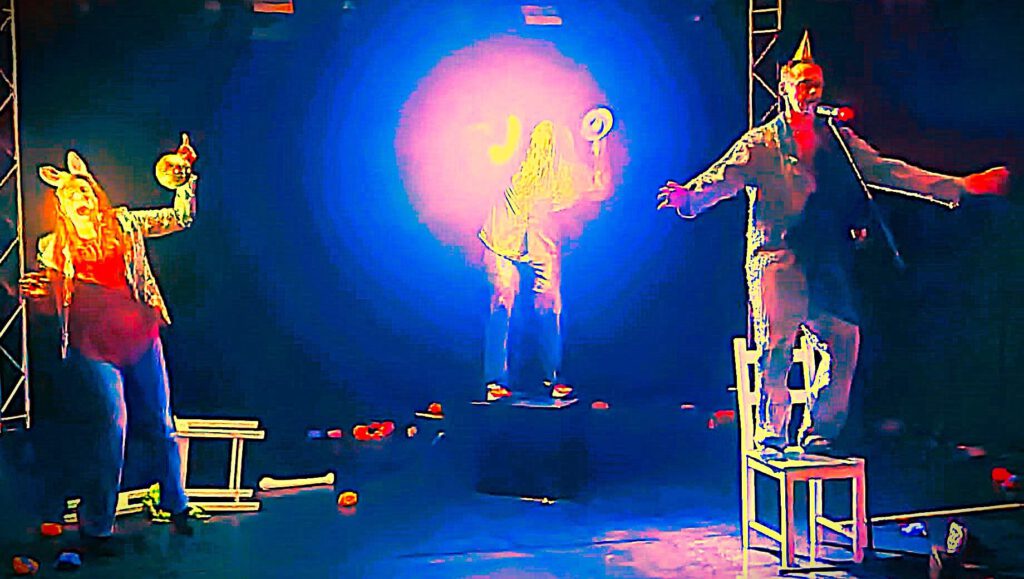 Drei Performer auf Bühne im blauen Licht